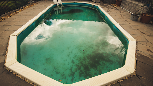 A pool with algae and dirt is shown after a storm.